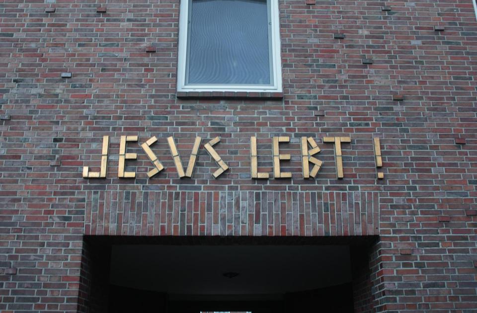 Die rückwärtige Seite des Portals des Friedhofs Heiligland. „Jesus lebt!“ steht in goldenen Lettern über dem Durchgang.